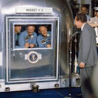 Präsident Nixon heißt die Apollo 11 Astronauten in Quarantäne willkommen, (von links nach rechts) Neil Armstong, Michael Collins, Edwin „Buzz“ Aldrin